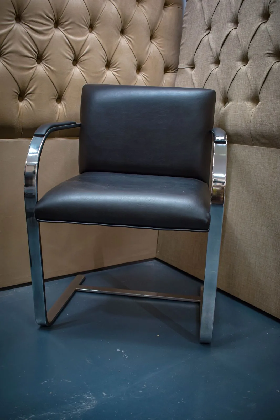 Sillón hecho en cuerina negra con 2 patas en acero macizo cromado